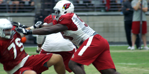 Defensive lineman Rodney Gunter runs over tackle Bradley Sowell during Cardinals training camp Aug....