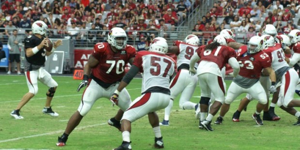Carson Palmer drops back to pass while Bobby Massie blocks during Arizona Cardinals training camp A...