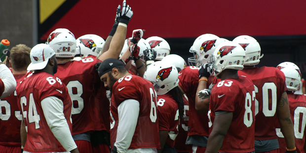 Cardinals players huddle up during training camp. (Photo by Adam Green/Arizona Sports)...