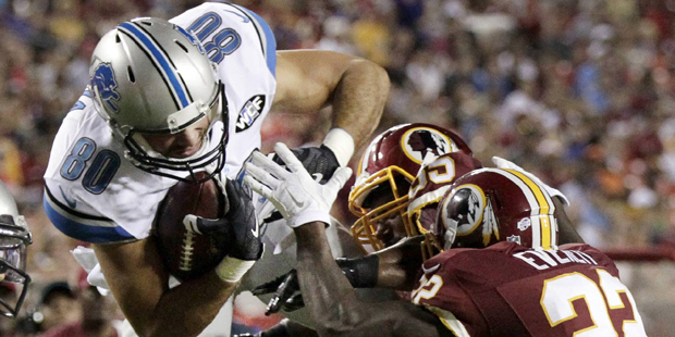 Detroit Lions tight end Joseph Fauria (80) pulls in a pass under pressure from Washington Redskins ...