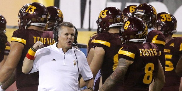 Arizona State head coach Todd Graham, left, talks with D.J. Foster (8) on the sidelines during the ...