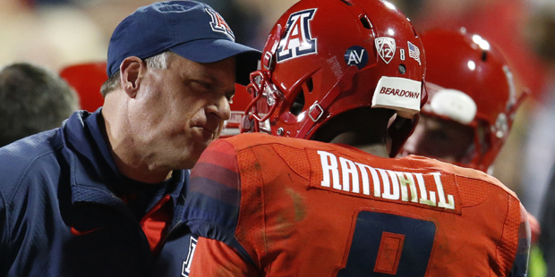 Arizona Wildcats head coach Rich Rodriguez, left, confers with quarterback Jerrard Randall (8) afte...