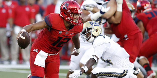 Arizona quarterback Anu Solomon (12) breaks away from UCLA defensive back John Johnson during the f...