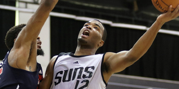 Phoenix Suns' T.J. Warren, right, goes for a layup past Washington Wizards' Jarrid Famous during th...
