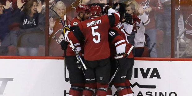 Arizona Coyotes' Connor Murphy (5), Boyd Gordon (15) and Nicklas Grossmann, left, of Sweden, surrou...
