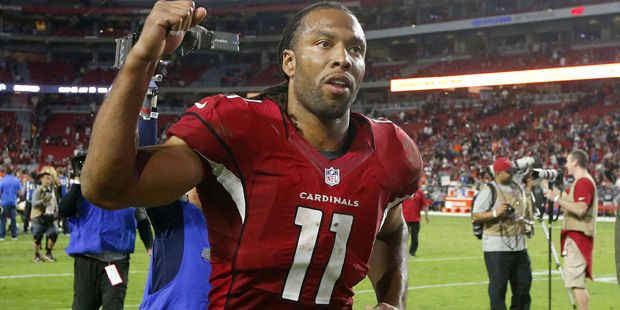 Arizona Cardinals' Larry Fitzgerald pumps his fist as he runs off the field after an NFL football g...