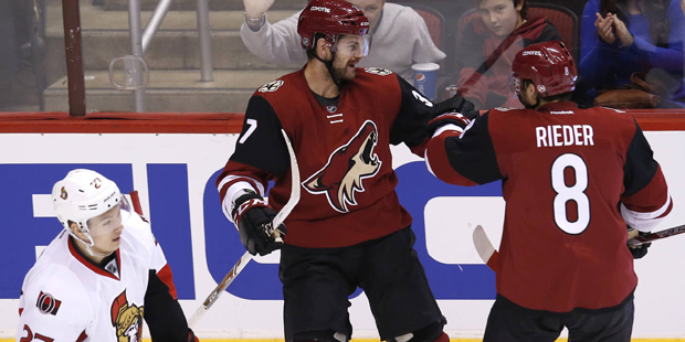 Arizona Coyotes center Dustin Jeffrey, middle, celebrates with Tobias Rieder (8) after scoring a go...