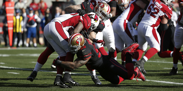 Arizona Cardinals running back Chris Johnson, center, is tackled by San Francisco 49ers linebacker ...