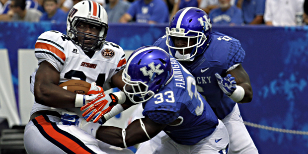 Kentucky defenders Ryan Flannigan (33) and Jason Hatcher (6) stop Tennessee-Martin running back Abo...
