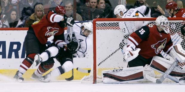 Arizona Coyotes defenseman Nicklas Grossmann, of Sweden, left, checks Los Angeles Kings' Anze Kopit...