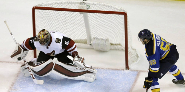 Arizona Coyotes goalie Mike Smith, left, deflects a puck as St. Louis Blues' Magnus Paajarvi watche...