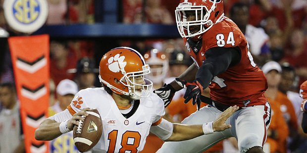 Clemson quarterback Cole Stoudt, left, scrambles to get away from the defense of Georgia's Leonard ...