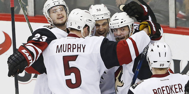 Arizona Coyotes Antoine Vermette, helmet number 50, is surrounded by teammates after scoring a sh...