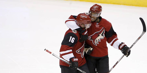 Arizona Coyotes' Max Domi (16) gets a hug from teammate Anthony Duclair, right, after Domi recorded...