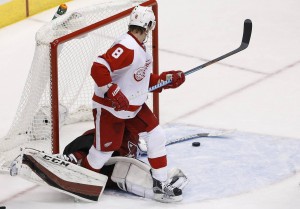 Arizona Coyotes' Louis Domingue, left, makes an initial save on a shot as he gets tangled up with Detroit Red Wings' Justin Abdelkader (8) during the third period of an NHL hockey game Thursday, Jan. 14, 2016, in Glendale, Ariz. The Red Wings' Gustav Nyquist would score on the play, and the Red Wings defeated the Coyotes 3-2 in overtime. (AP Photo/Ross D. Franklin)