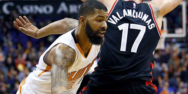 Phoenix Suns' Markieff Morris drives past Toronto Raptors' Jonas Valanciunas, of Lithuania, (17) du...