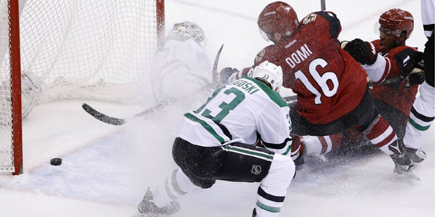 Arizona Coyotes' Max Domi (16) scores a goal against Dallas Stars' Antti Niemi, back left, of Finla...