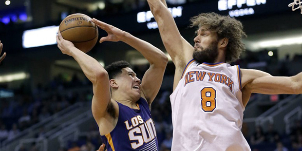 Phoenix Suns' Devin Booker drives against New York Knicks' Robin Lopez (8) during the second half o...