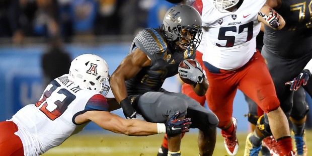 Arizona linebacker Scooby Wright III (33) and linebacker Cody Ippolito (57) close in on UCLA runnin...