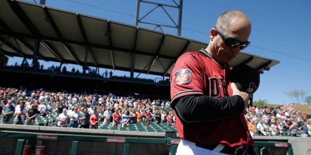 Arizona Diamondbacks manager Chip Hale bow his head during a moment of silence for Joe Garagiola be...