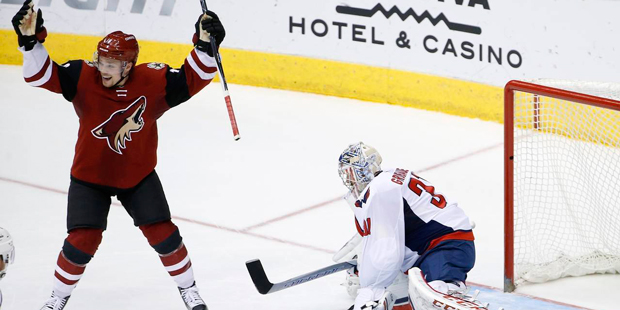 Arizona Coyotes' Max Domi, left, celebrates a goal by teammate Brad Richardson against Washington C...