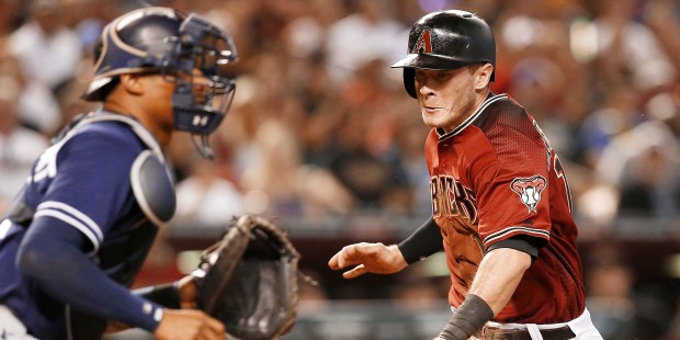 Arizona Diamondbacks Nick Ahmed, right, scores in front of San Diego Padres catcher Christian Betha...
