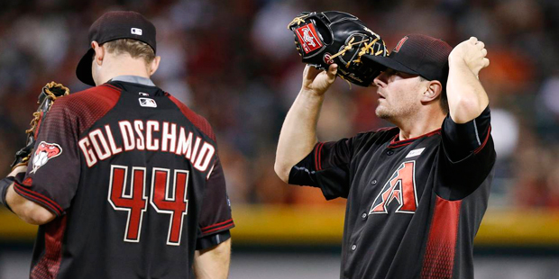 Arizona Diamondbacks pitcher Daniel Hudson, right, pauses at the mound with Paul Goldschmidt (44) a...