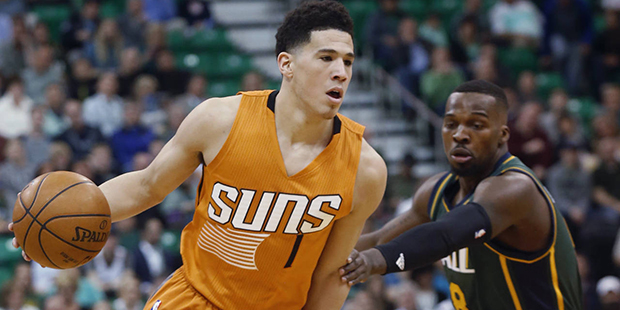 Phoenix Suns' Devin Booker (1) drives around Utah Jazz's Shelvin Mack (8) during the first half of ...