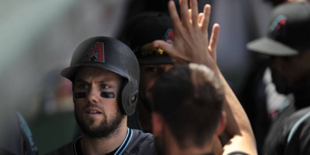 Arizona Diamondbacks' Chris Owings celebrates with teammates in the dugout after scoring on a Yasma...