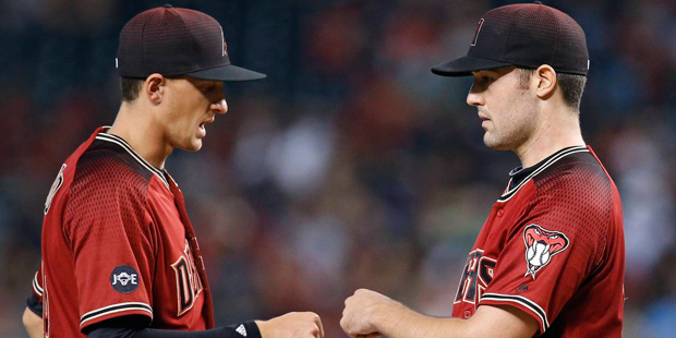 Arizona Diamondbacks pitcher Robbie Ray, right, gets a fist pump from Nick Ahmed, left, as Ray is t...