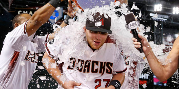 Arizona Diamondbacks' Brandon Drury (27) gets a bucket of ice dumped on him by Yasmany Tomas, left,...