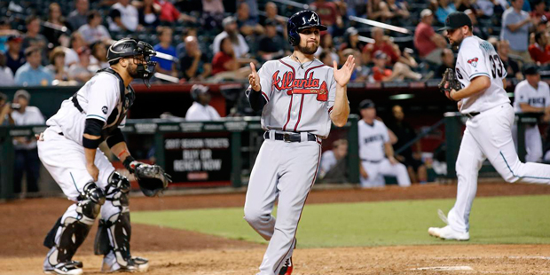 Atlanta Braves' Ender Inciarte, middle, applauds as he scores, while Arizona Diamondbacks' Welingto...