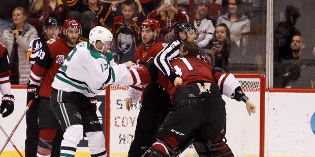 Arizona Coyotes goalie Mike Smith (41) is restrained by linesman Darren Gibbs as he tries to go aft...