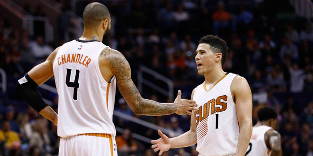 Phoenix Suns guard Devin Booker (1) slaps hands with Tyson Chandler (4) during the closing moments ...