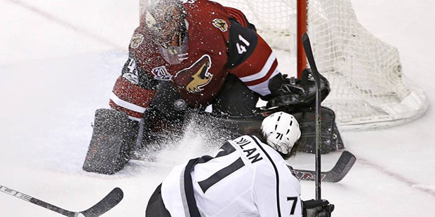 Los Angeles Kings center Jordan Nolan (71) sends the puck at Arizona Coyotes goalie Mike Smith (41)...