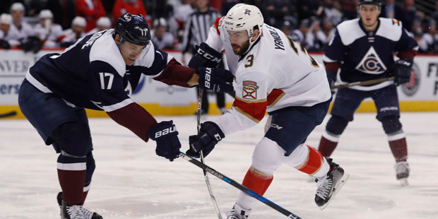 Colorado Avalanche right wing Rene Bourque, left, uses his stick to block a shot by Florida Panther...