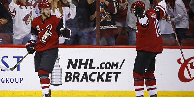 Arizona Coyotes' Josh Jooris, left, celebrates his goal against the Washington Capitals with Anthon...