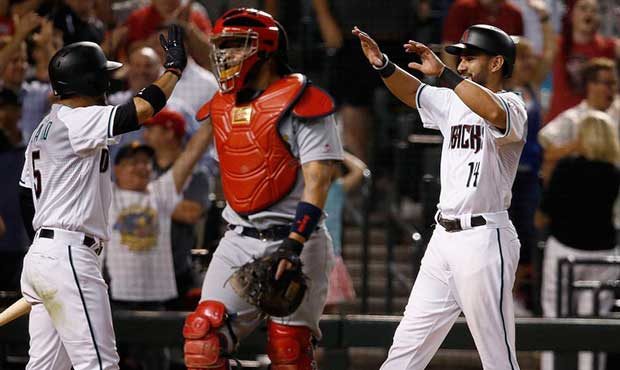 Arizona Diamondbacks' Reymond Fuentes (14) celebrates his game-wining run with Gregor Blanco (5) as...