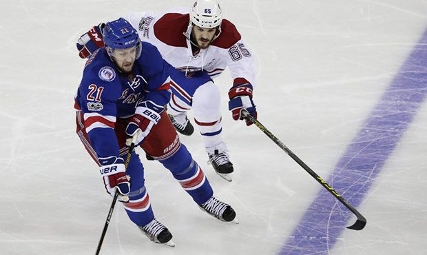 New York Rangers' Derek Stepan (21) fights for control of the puck with Montreal Canadiens' Andrew ...