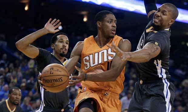 Phoenix Suns' Brandon Knight, center, passes between Golden State Warriors' Shaun Livingston, left,...