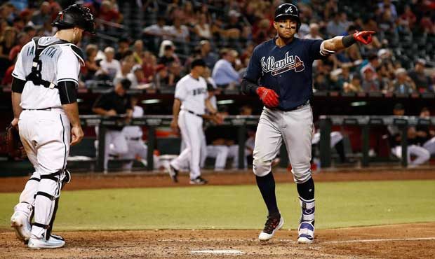 Atlanta Braves' Johan Camargo, right, points to his teammates as he arrives at home plate after hit...