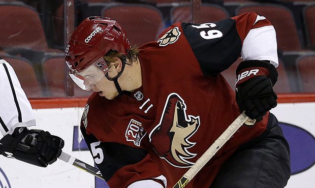 Arizona Coyotes' Kyle Wood (65) battles with Los Angeles Kings' Matt Luff (64) for the puck during ...