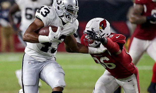 Oakland Raiders running back John Crockett (43) is hit by Arizona Cardinals safety Budda Baker (36)...