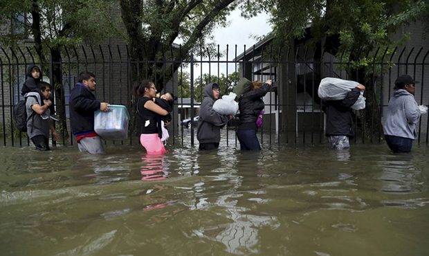 Residents from Bayou Parc at Oak Forest carry their belongings while evacuating the apartment compl...