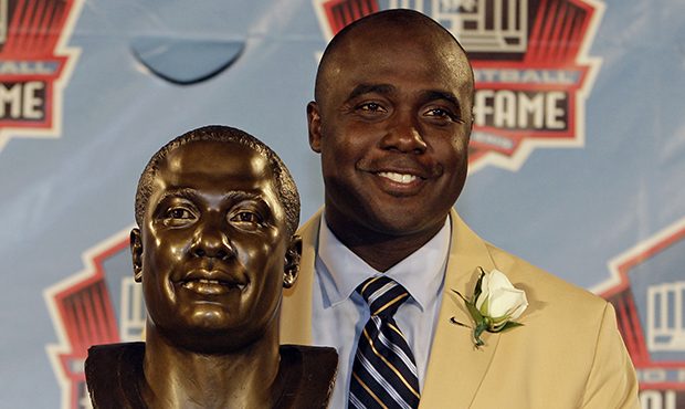 Marshall Faulk poses with a bust of himself during the induction ceremony at the Pro Football Hall ...