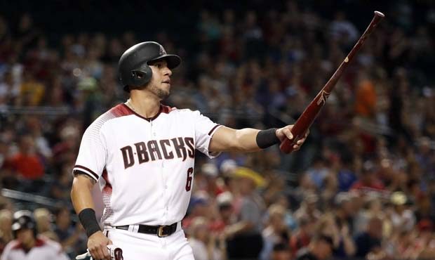 Arizona Diamondbacks' David Peralta points to teammate Jake Lamb after scoring on a hit by Lamb dur...
