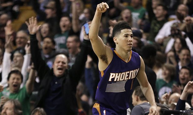 Phoenix Suns guard Devin Booker gestures after he scored a basket, as fans cheer him at TD Garden i...