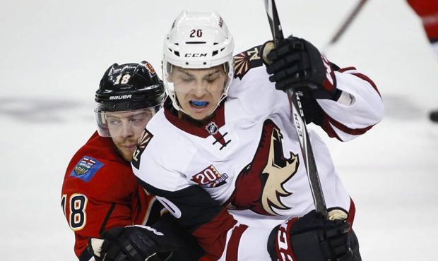 Arizona Coyotes' Dylan Strome, right, tries to get past Calgary Flames' Matt Stajan during the seco...