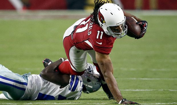 Arizona Cardinals wide receiver Larry Fitzgerald (11) stretches for yards as he is hit by Dallas Co...