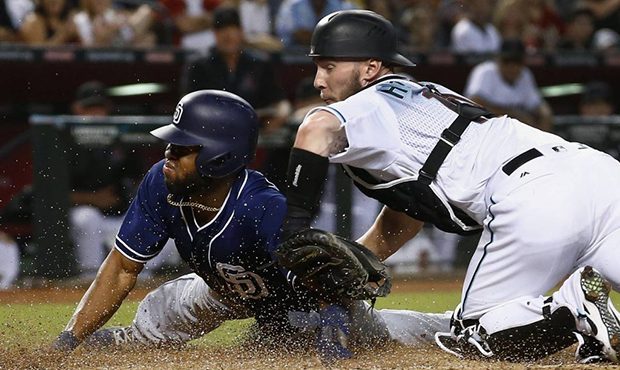 Arizona Diamondbacks' Chris Herrmann, right, tags out San Diego Padres' Manuel Margot, left, as Mar...